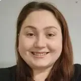 Women smiling directly into the camera with a short and fair dark hair and dark eyes