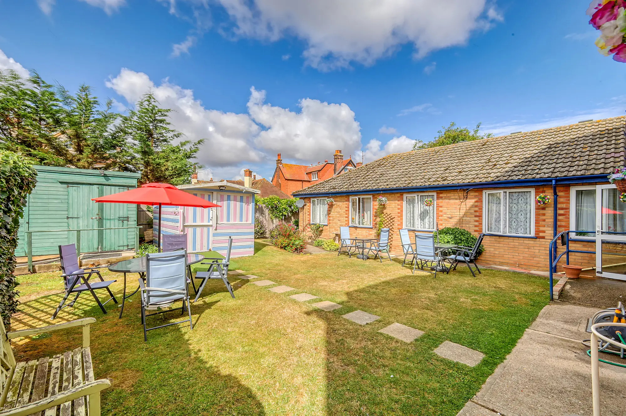 picture of the garden, including garden furniture and two large sheds
