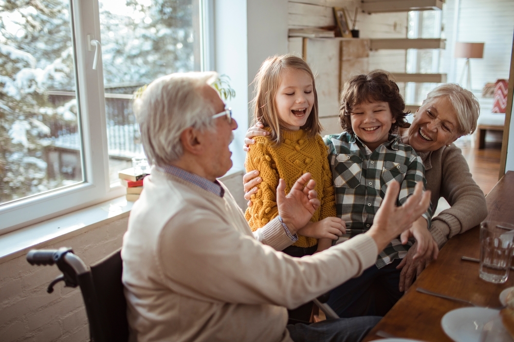 Grandparents having fun with grandchildren at cozy home lunch